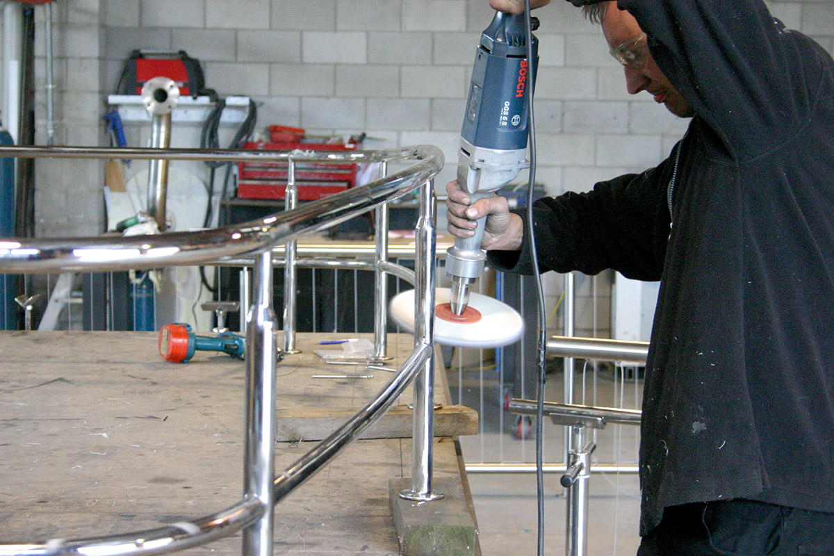 Image showing a Contab International worker, using a tool while working on a stainless steel project inside the Contab International factory.